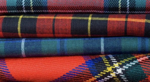 Stapeltje tartan stoffen in rood, groen, zwart en blauw