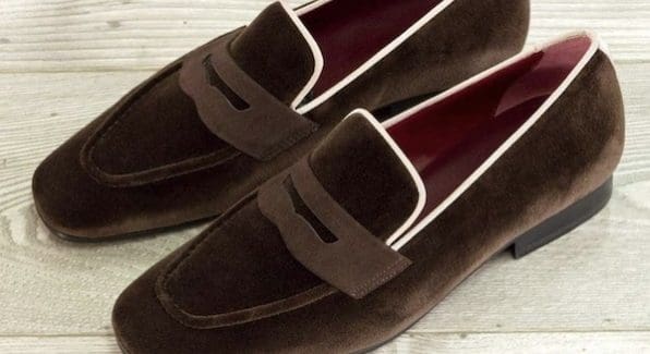 Bruine suède instappers voor heren met een crème biesje langs de randen.