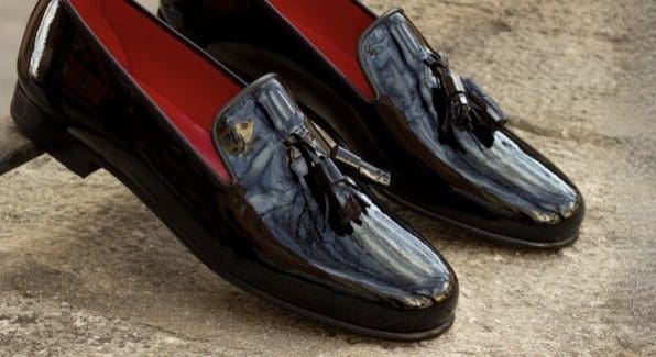 Zwart lakleren heren slipper met zwart leren kwasten en een rood lederen binnenkant.