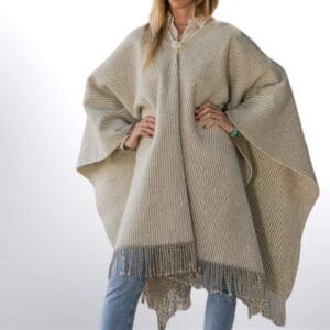 model met een gestreepte traditionele spaanse poncho in naturel kleuren