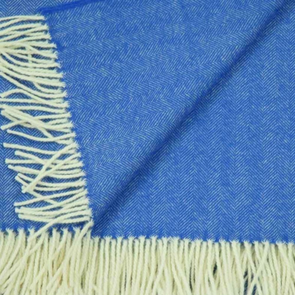 Detail van een lamswollen omslagdoek met franjes